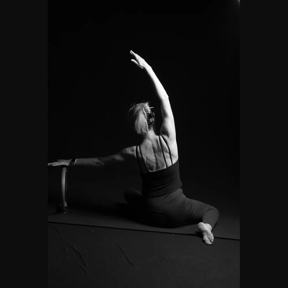 Florence in a seated mermaid stretch, viewed from behind