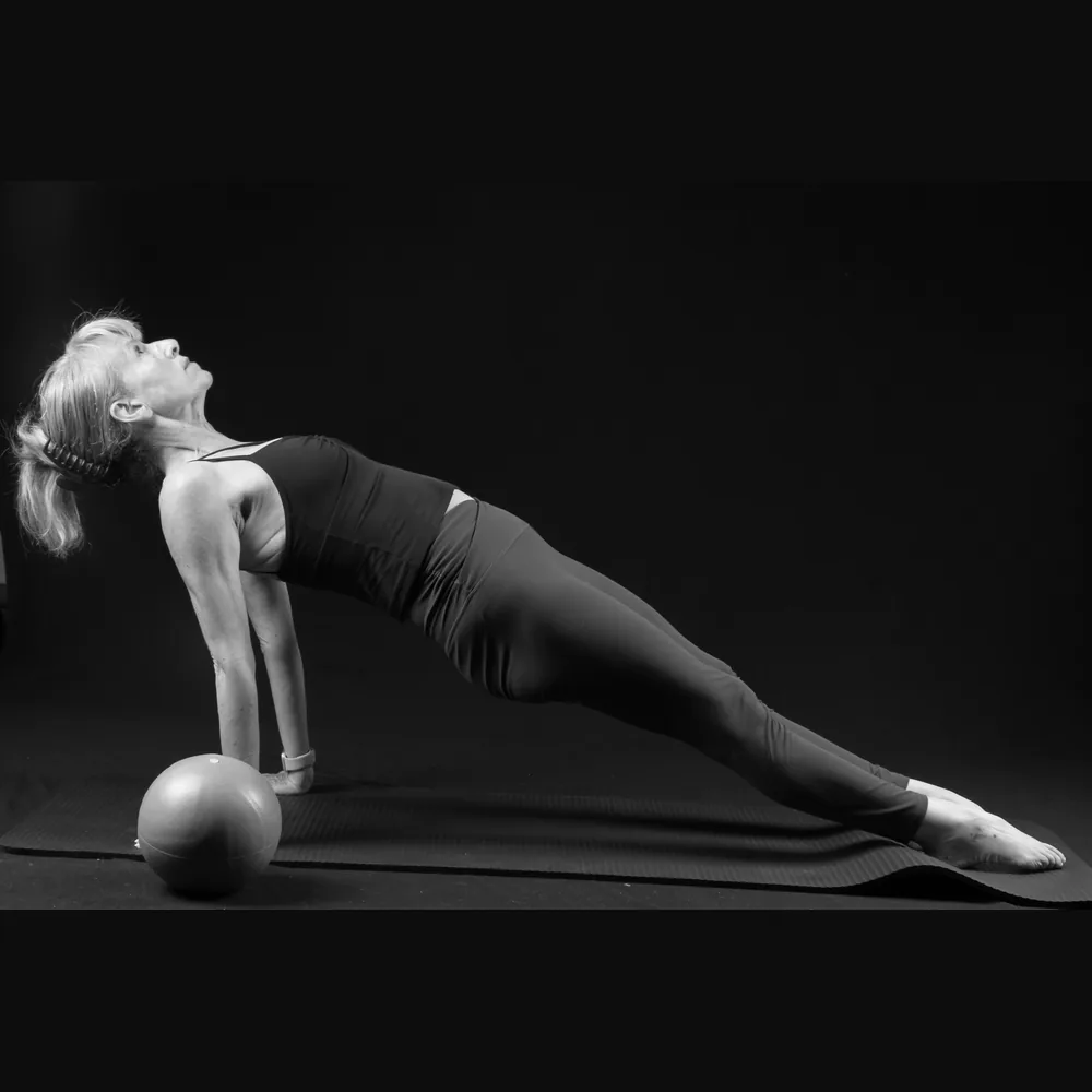 Florence in a reverse plank with a Pilates ball